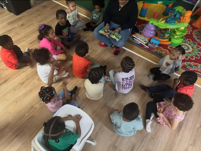 Eastwood children gathered in a morning circle while their teacher reads aloud